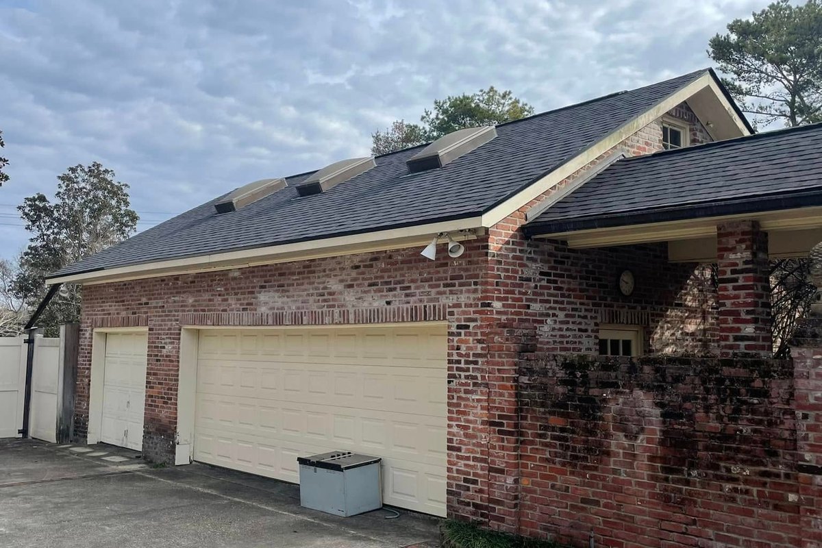 Dark charcoal architectural shingle roof on a red brick house