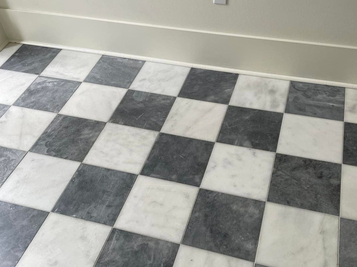 Checkerboard floor of white and dark gray marble tile on the diagonal