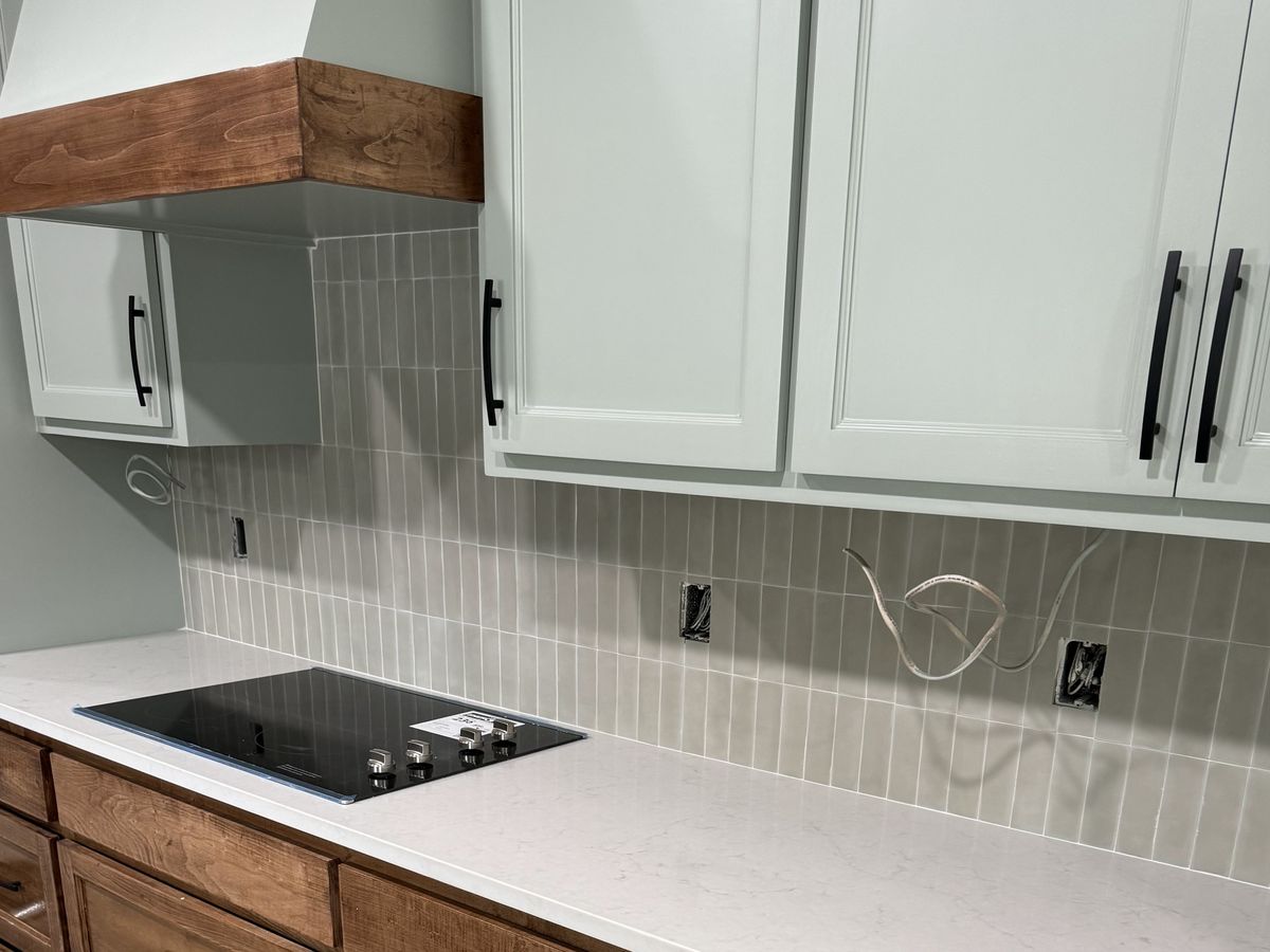 White quartz counter with a black glass cooktop