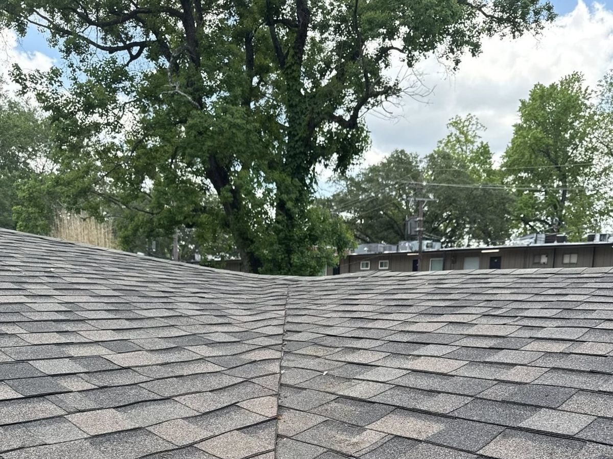 Gray architectural shingles meeting in a clean roof valley