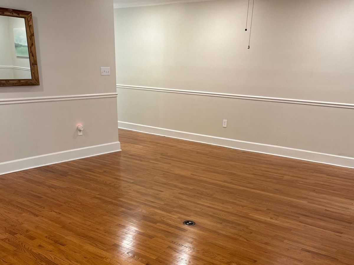 Refinished oak floor below white chair rail and a mirror