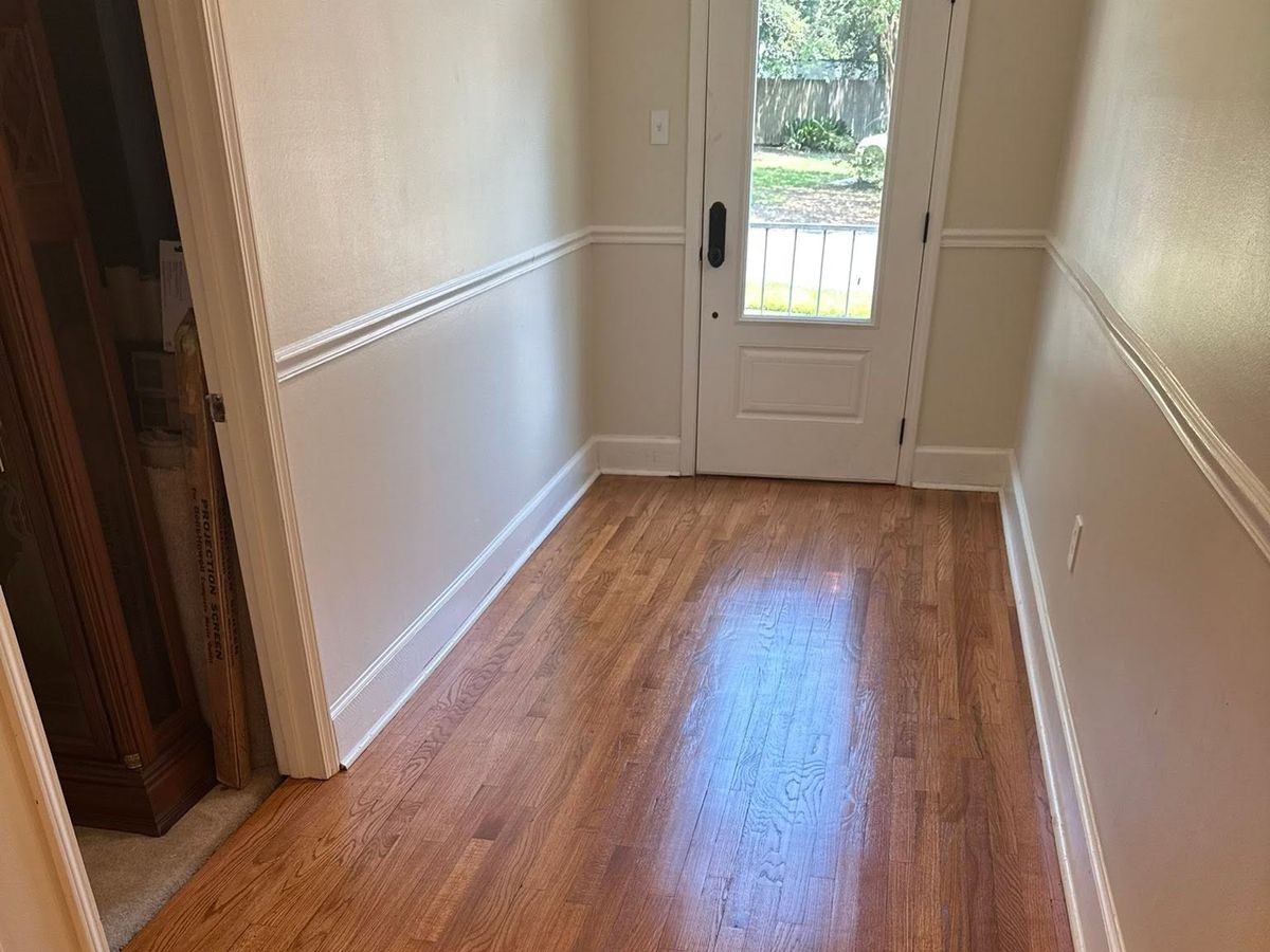 Honey-toned oak foyer floor under a white chair rail