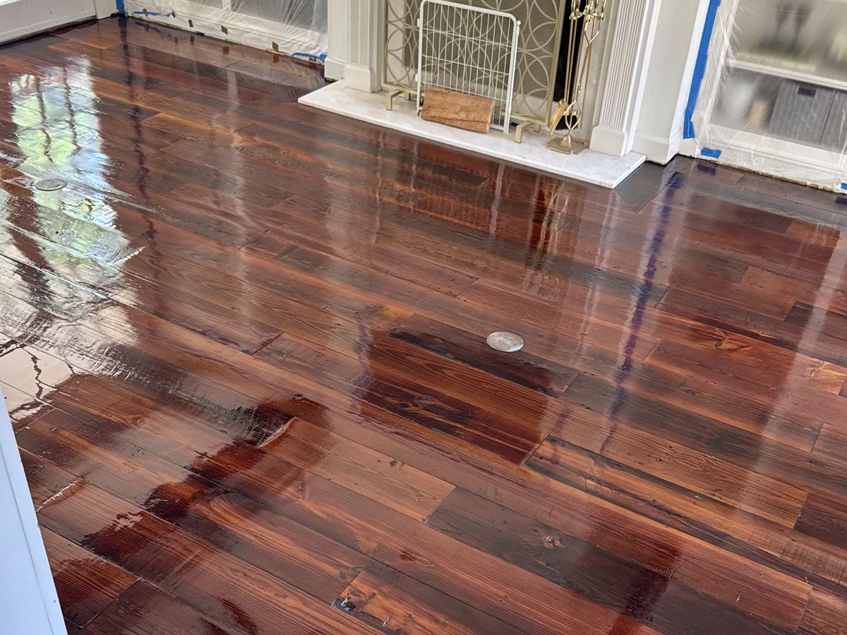 Wet high-gloss pine floor in front of a white fireplace