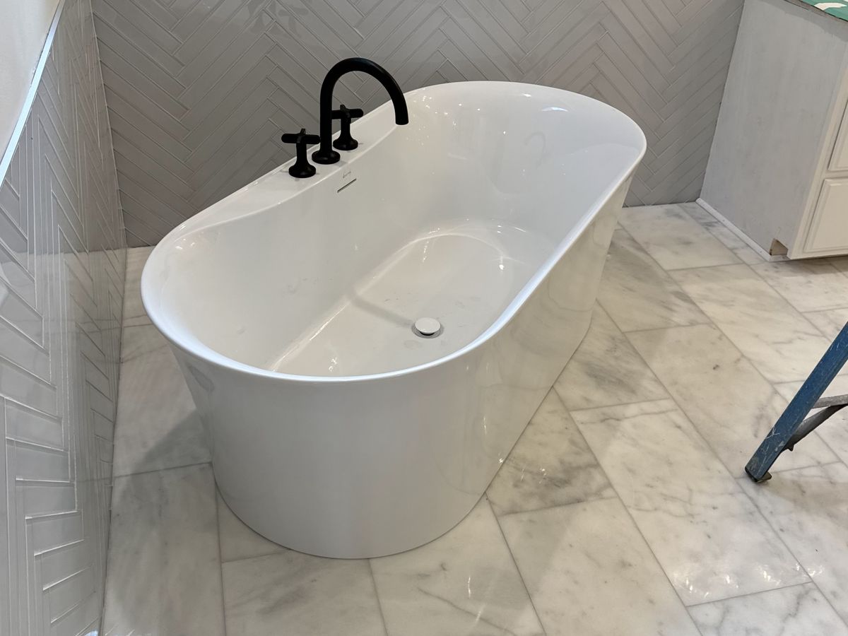 Soaking tub on a white marble-look tile floor