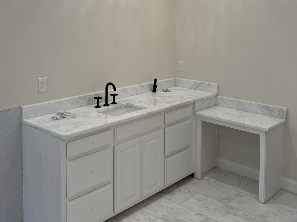 Bathroom vanity wall with a white cabinet and marble top