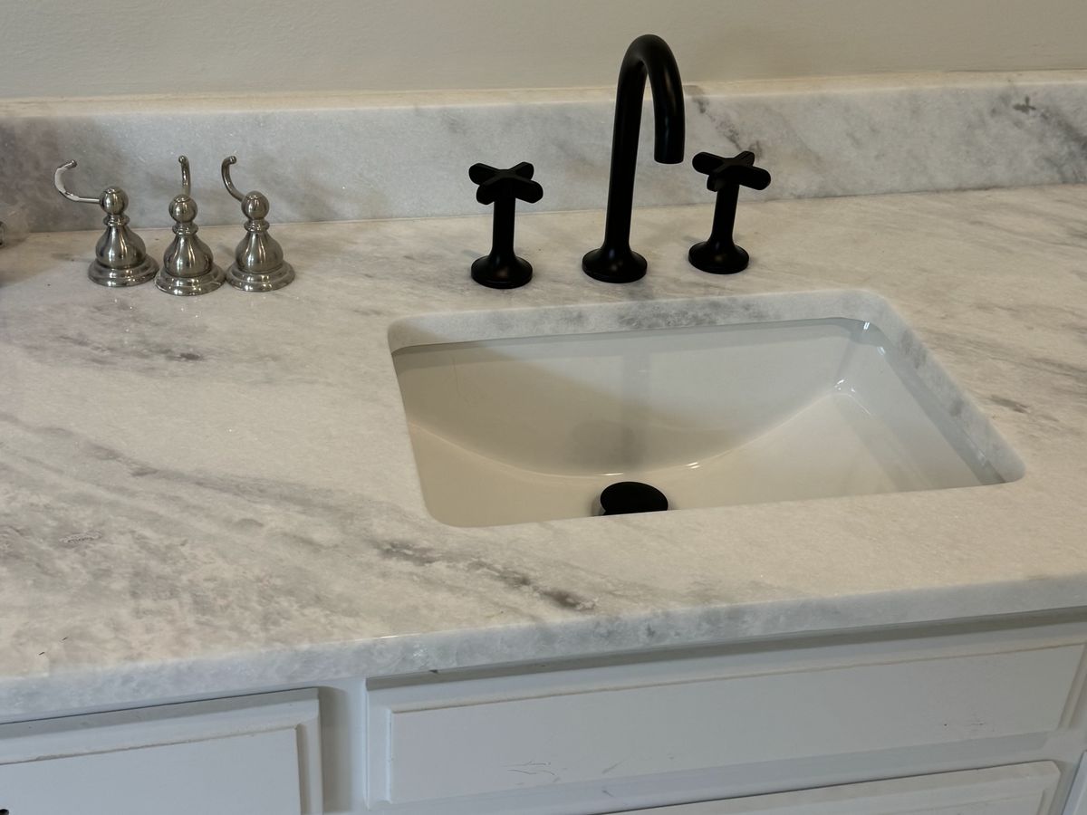 White bathroom vanity with a gray-veined marble top