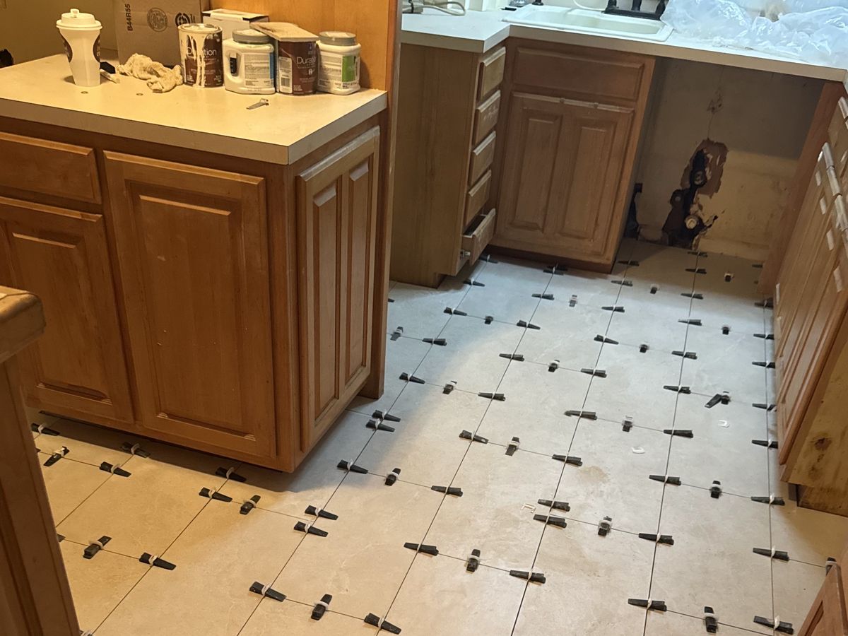 Cream porcelain kitchen tile set with black leveling clips