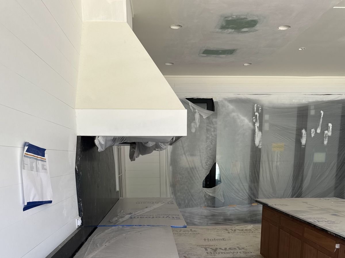 Kitchen mid-renovation with a big white range hood