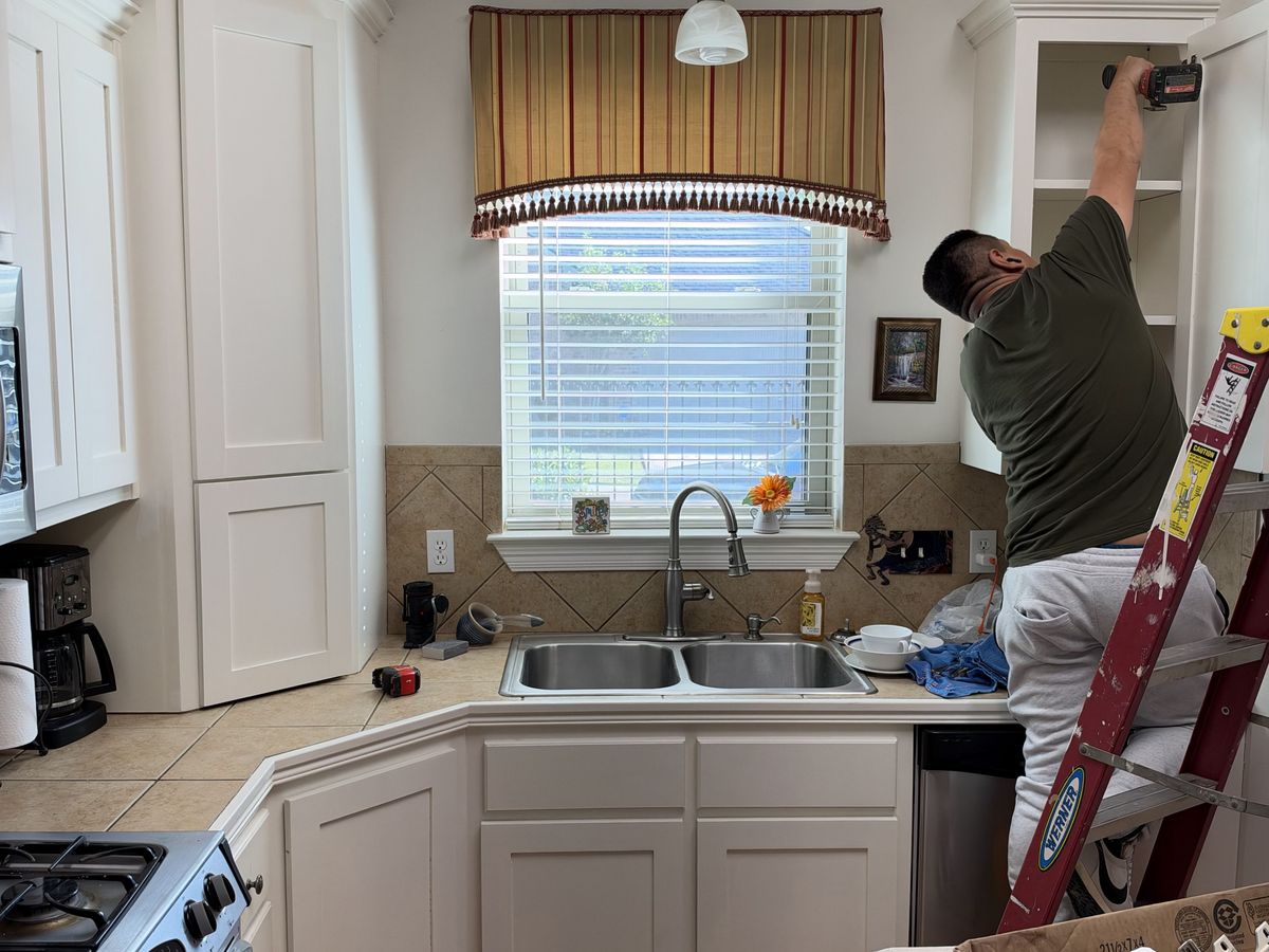 White painted kitchen cabinets with a double sink under a window