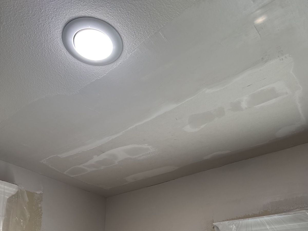 Room corner mid-repair with patches around a recessed light
