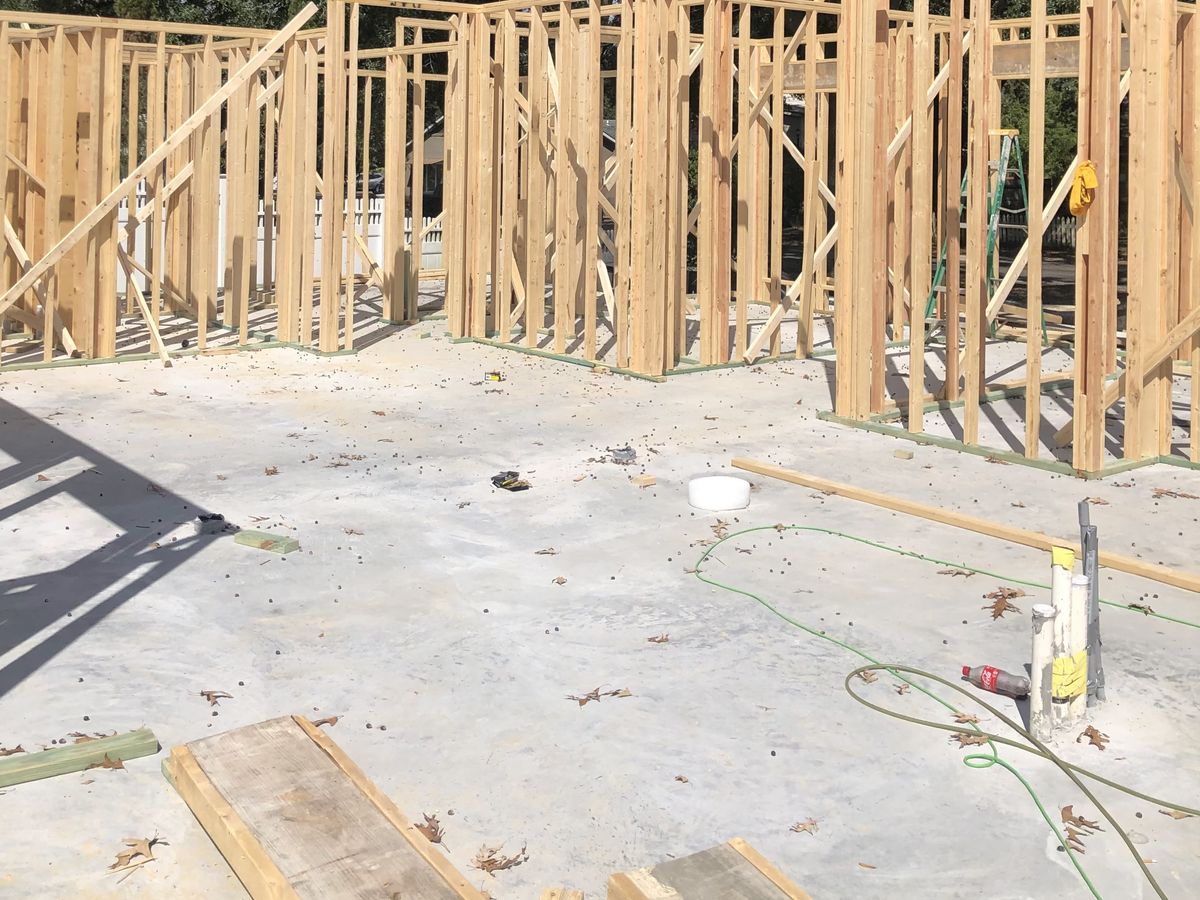 New home walls framed in wood studs atop a poured slab