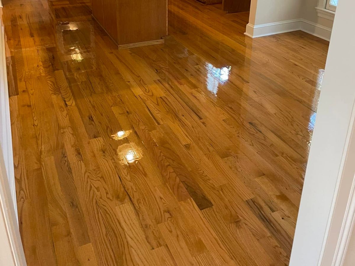 A high-gloss red oak kitchen floor by honey-stained wood cabinets