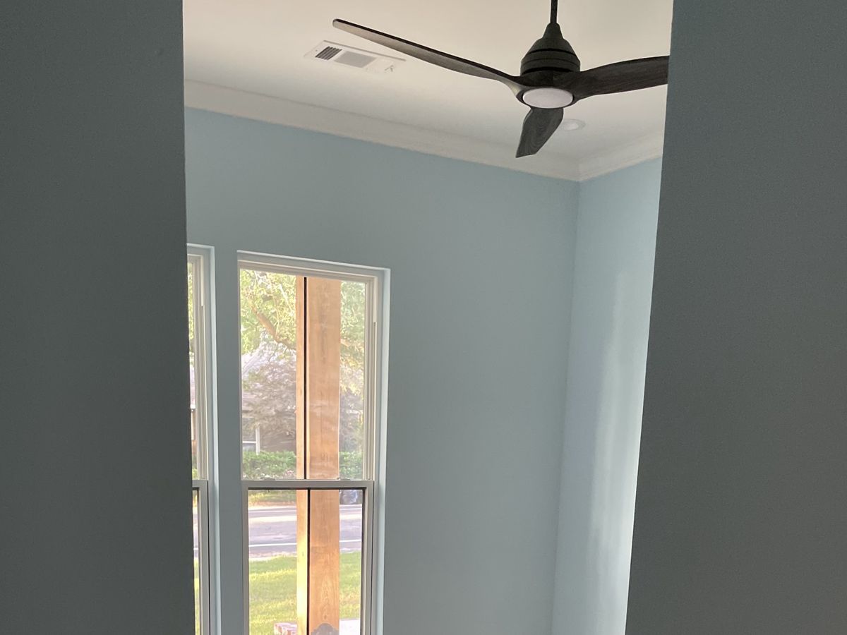 Pale blue painted bedroom seen through a doorway
