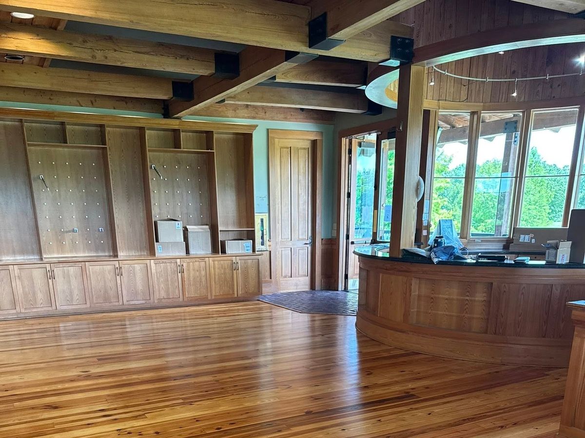 Heart pine floor by a curved wood counter and windows