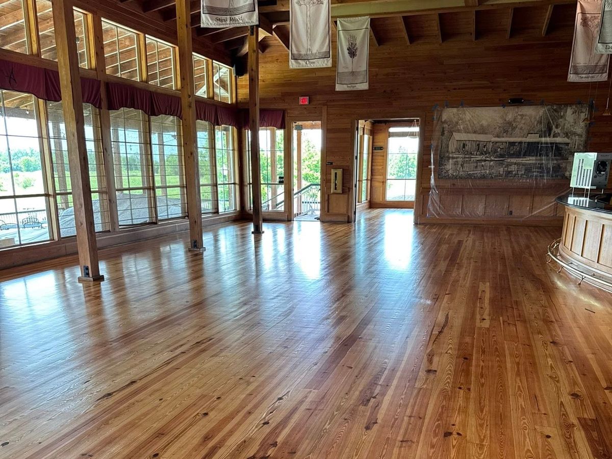Refinished pine floor down a hall with rows of windows