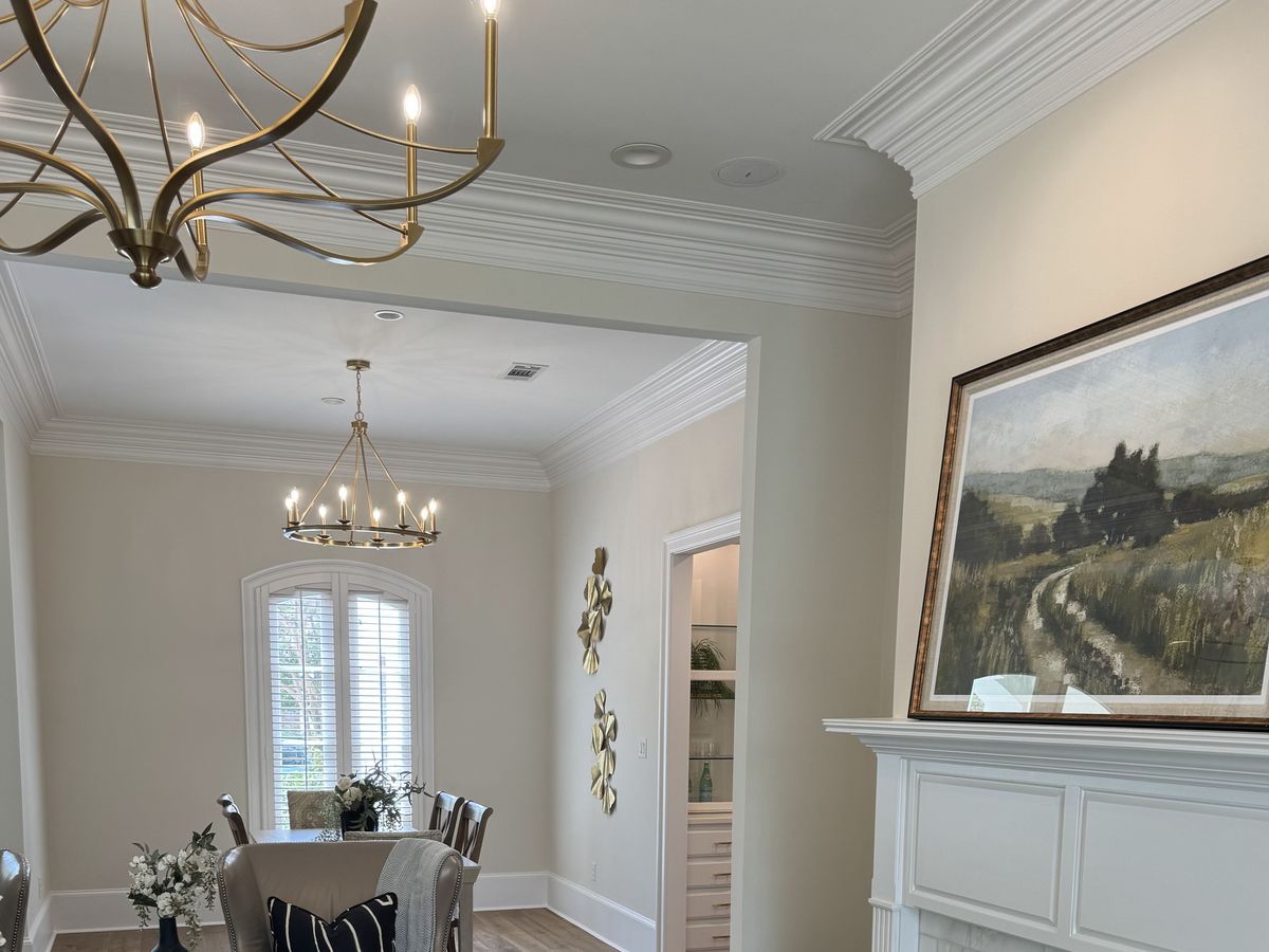Oak floors beneath gold chandeliers and an arched window