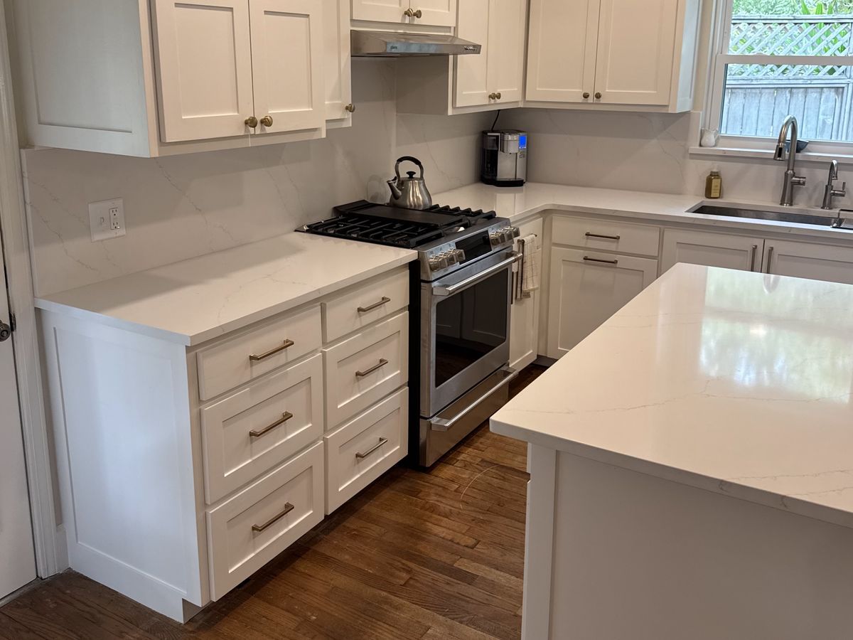 Remodeled kitchen with white shaker cabinets to the ceiling