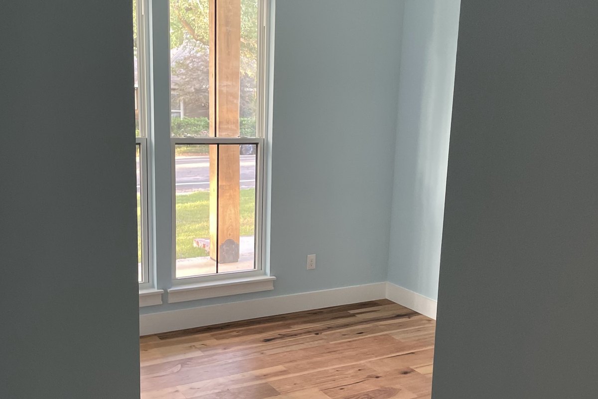 Freshly painted pale blue walls with a black ceiling fan