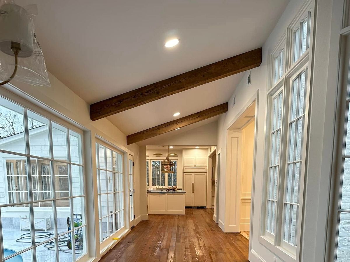 Glossy heart pine floor with a border in a long sunroom