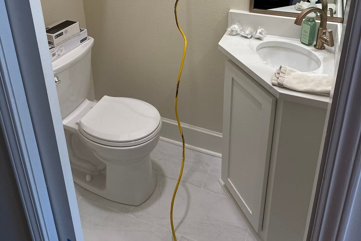 Small remodeled half bath with a white corner vanity