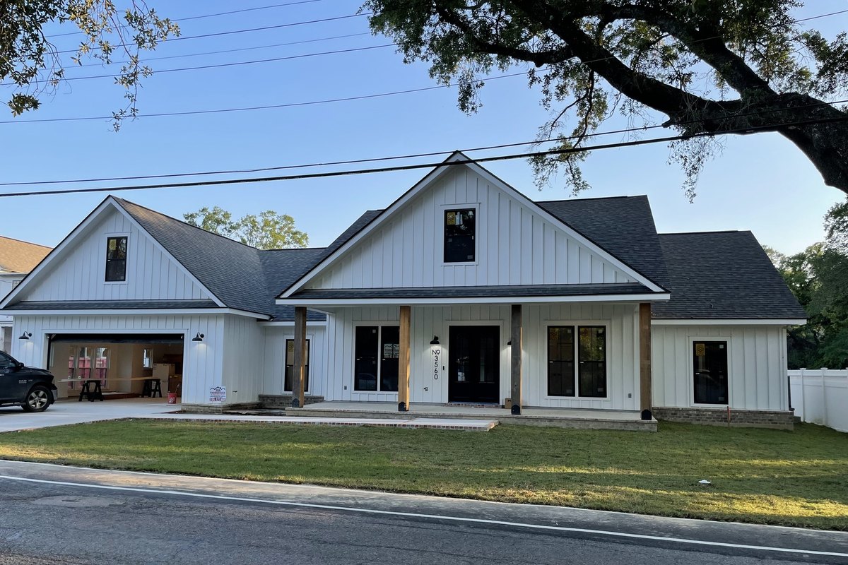 Street view of a finished white modern farmhouse