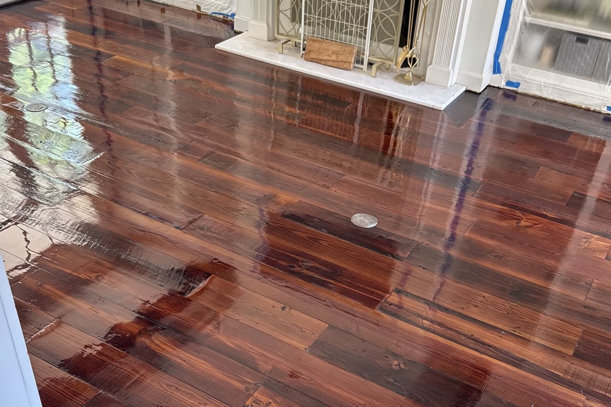 Wide-plank pine floor finished in a deep red-brown stain