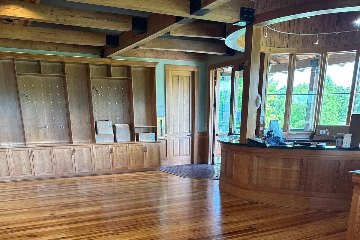 Open lodge-style room floored in refinished heart pine