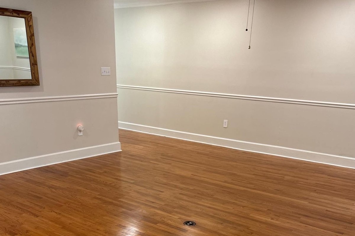 An empty room showing a satin-finish honey red oak floor