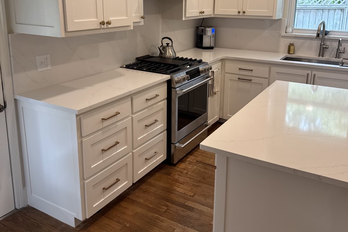 Remodeled kitchen with white shaker cabinets to the ceiling