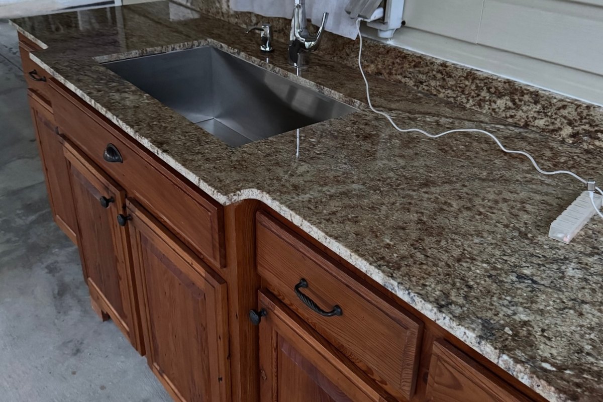 Outdoor kitchen with stained pine cabinets and granite