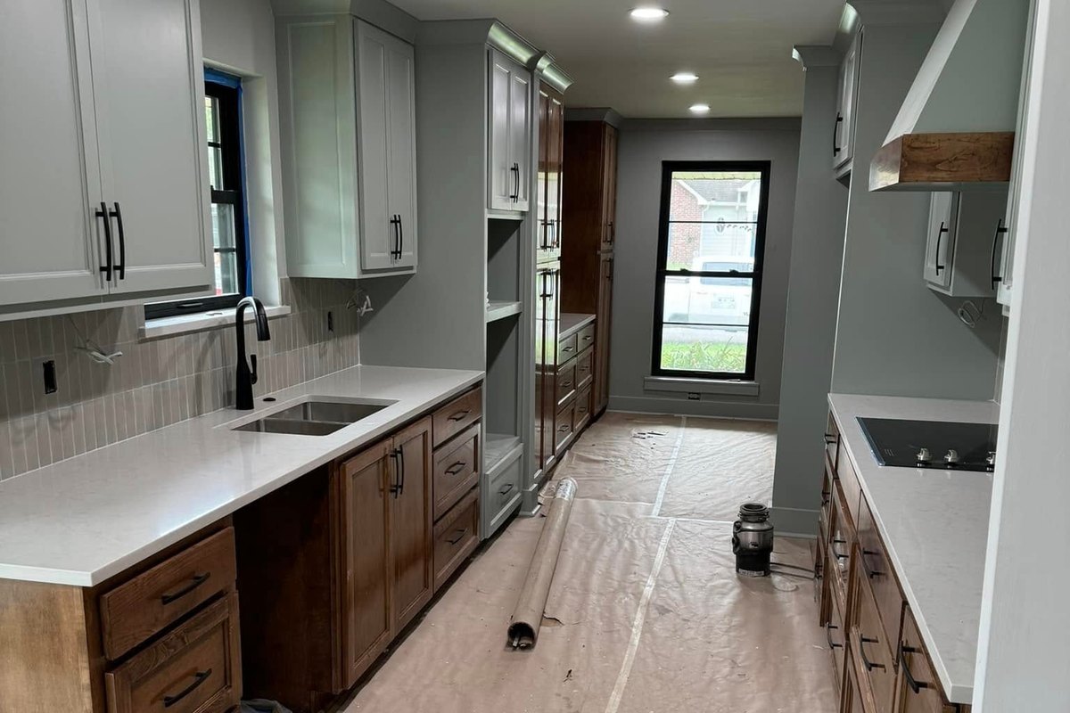 Galley kitchen nearing completion with gray and wood cabinets