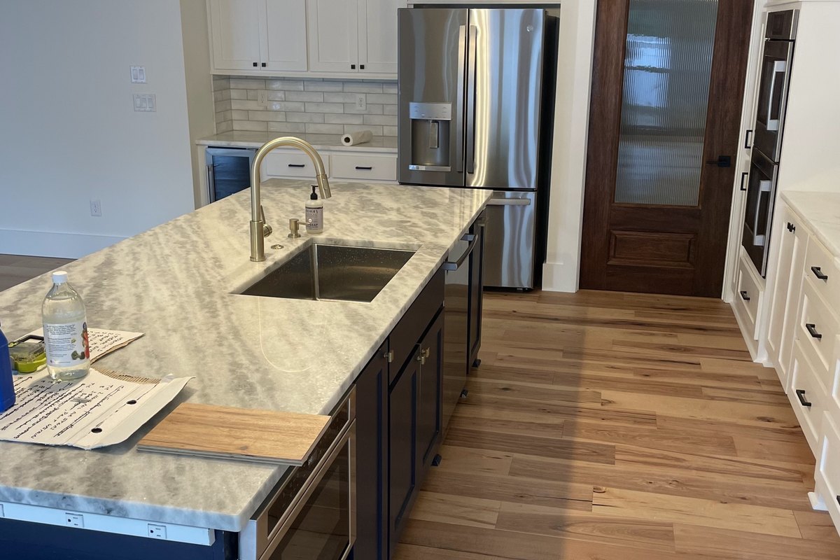 New kitchen with a navy blue island and stone countertop