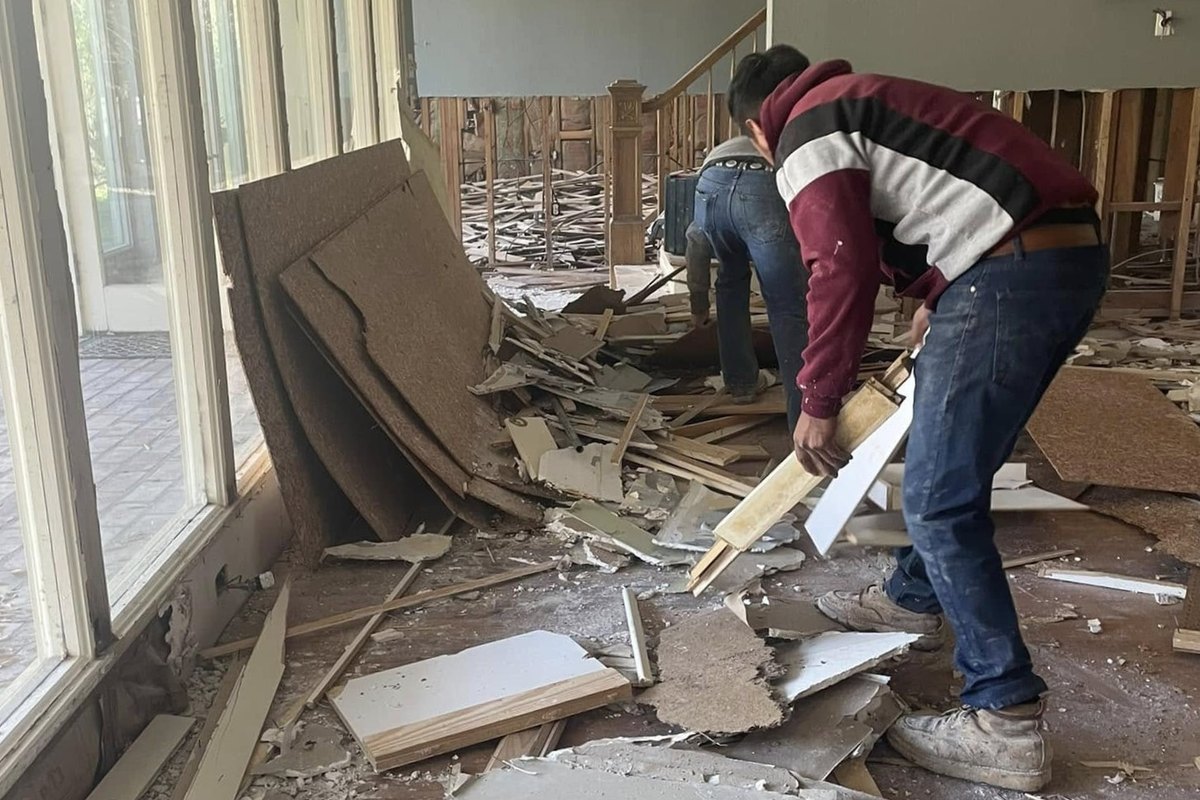 Interior demolition with walls opened to the studs and debris on the floor