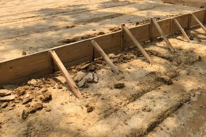Slab form boards with diagonal stakes along a graded house pad