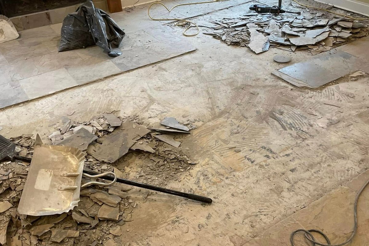 Old slate-look tile being chipped up in a living room