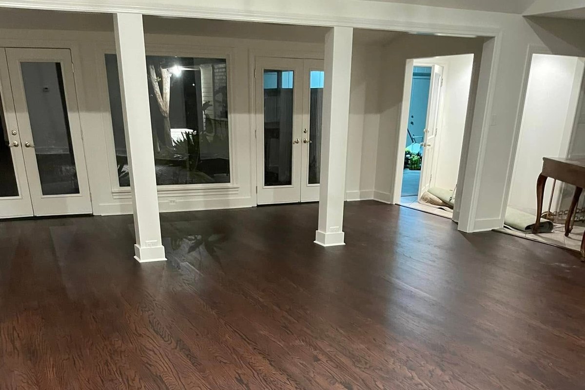 Large open room with a refinished oak floor stained dark walnut