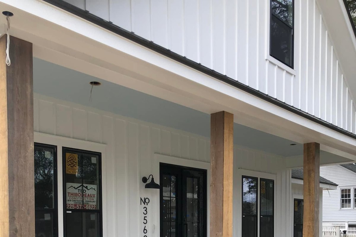 Covered front porch of a white board-and-batten farmhouse