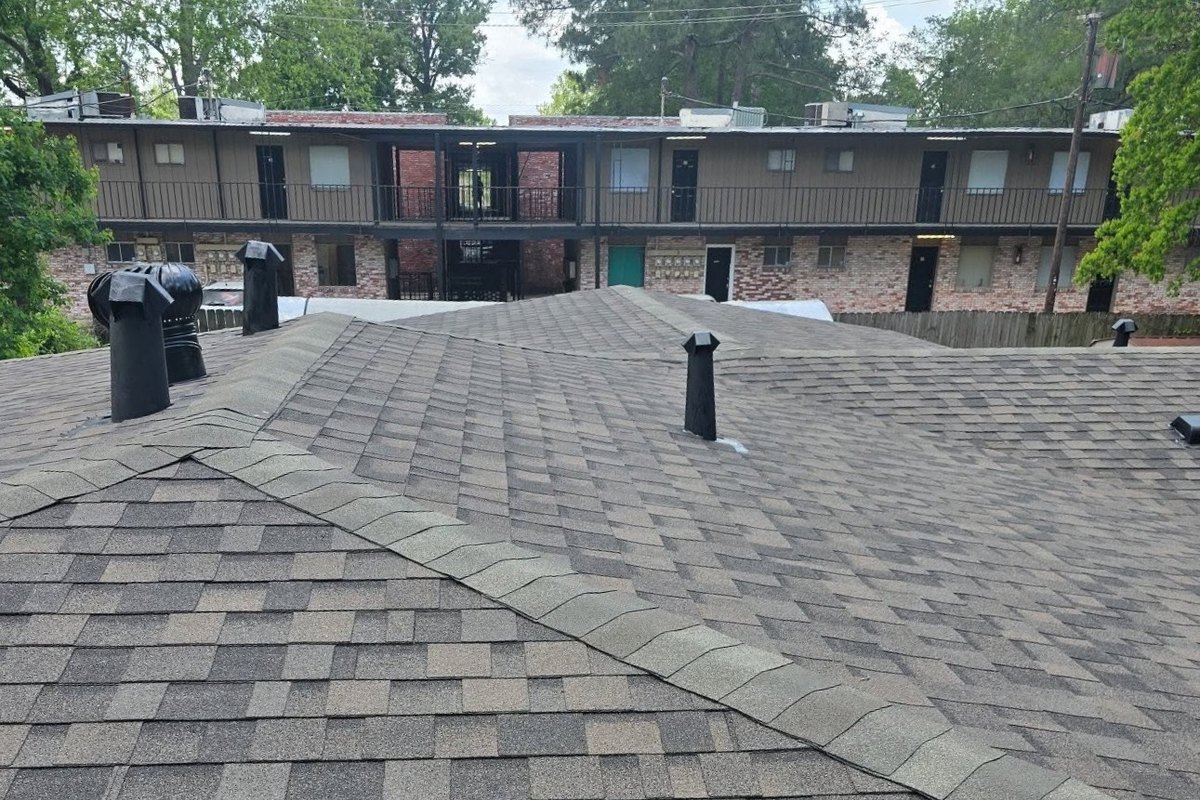 Shingle roof with a ridge cap line and black roof vents