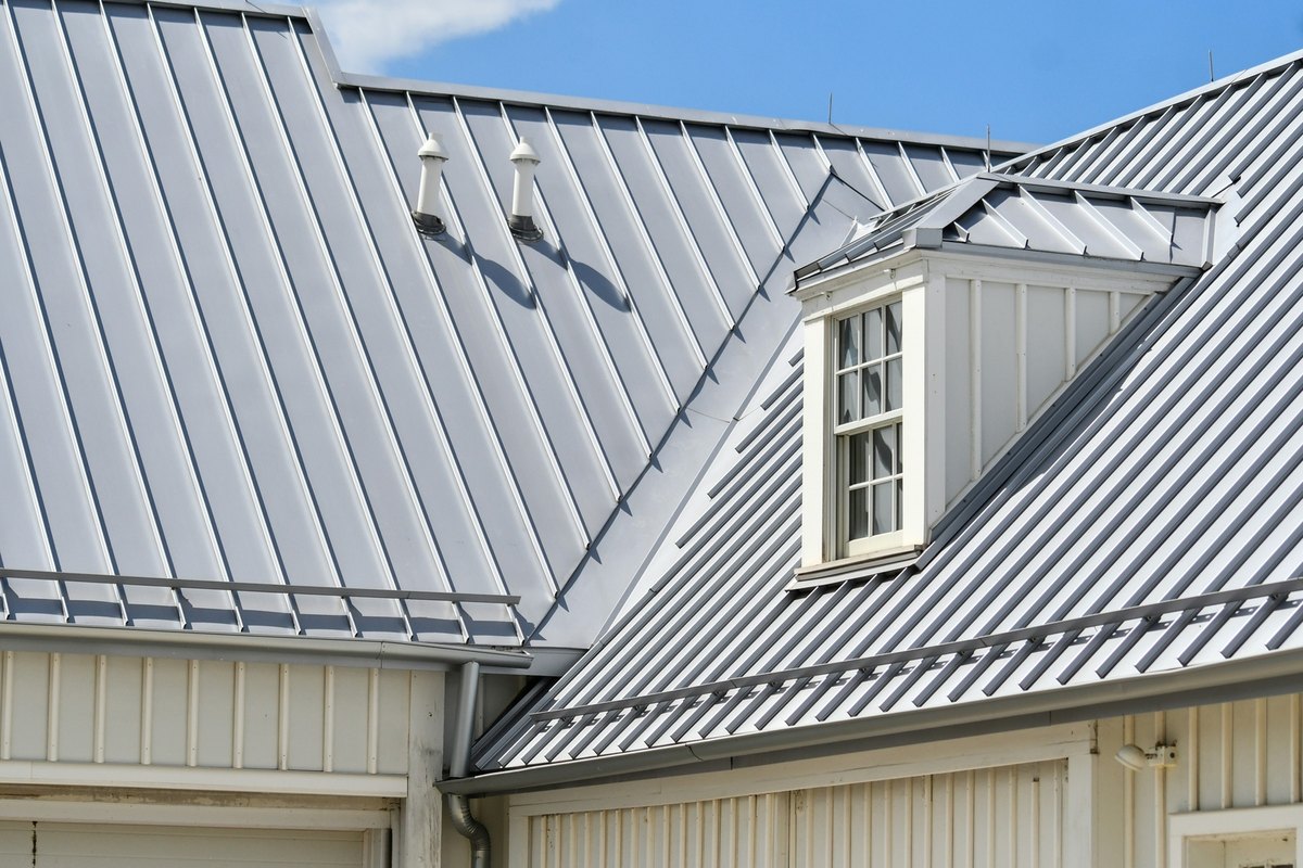 New gray standing-seam metal roof with a white dormer window