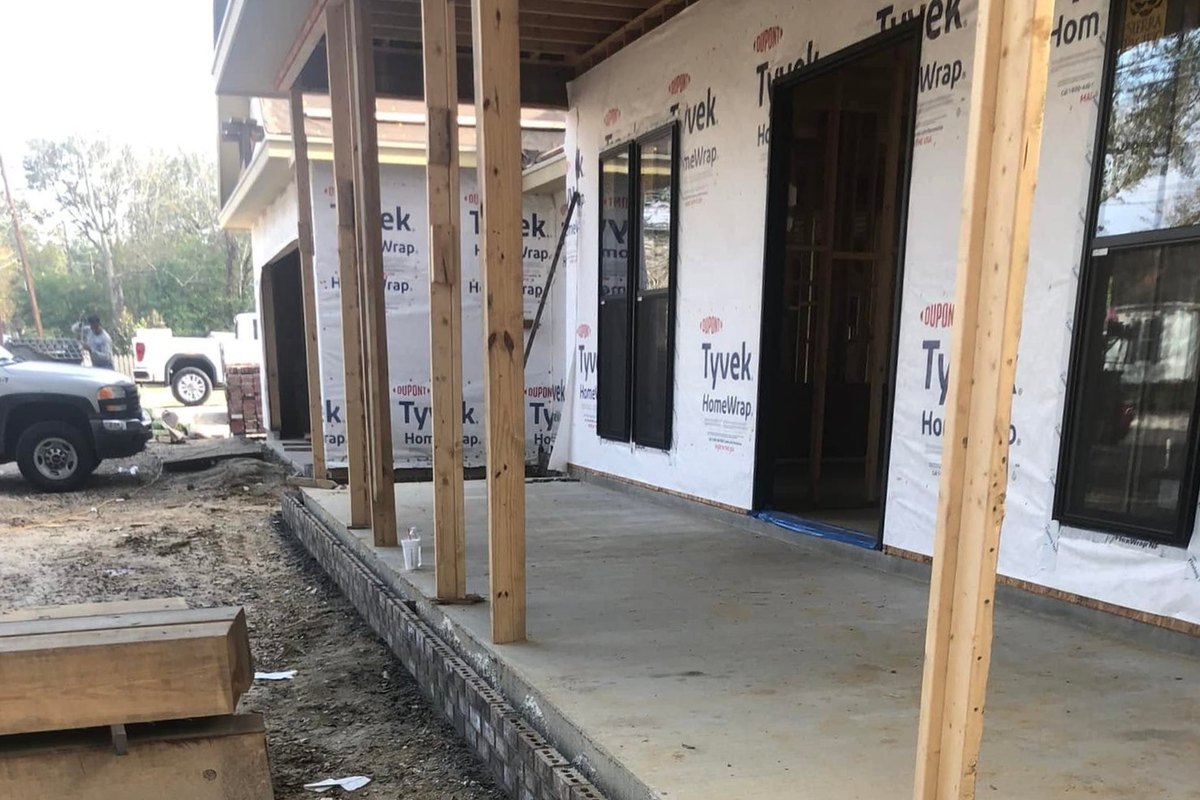 Porch of a wrapped home with black-framed glass doors