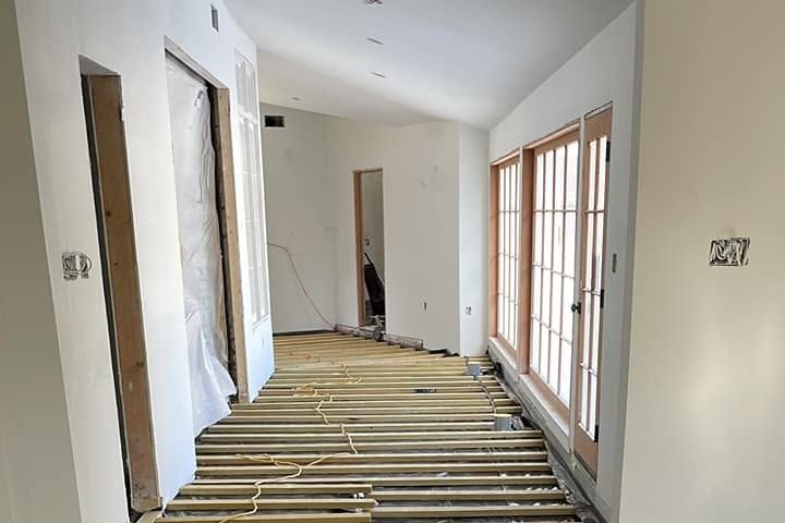 Long hallway with wood sleepers over a black vapor barrier