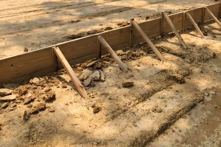 Staked wood forms edging a graded house pad