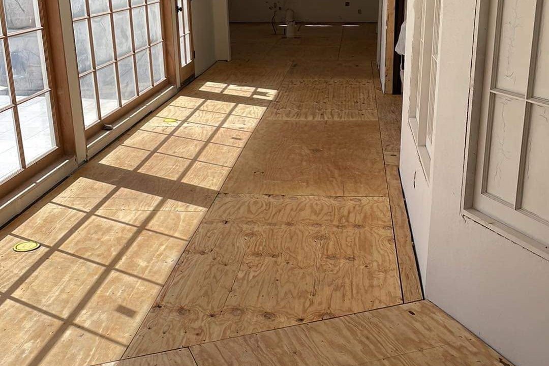Long sunroom with a new plywood subfloor laid in sheets