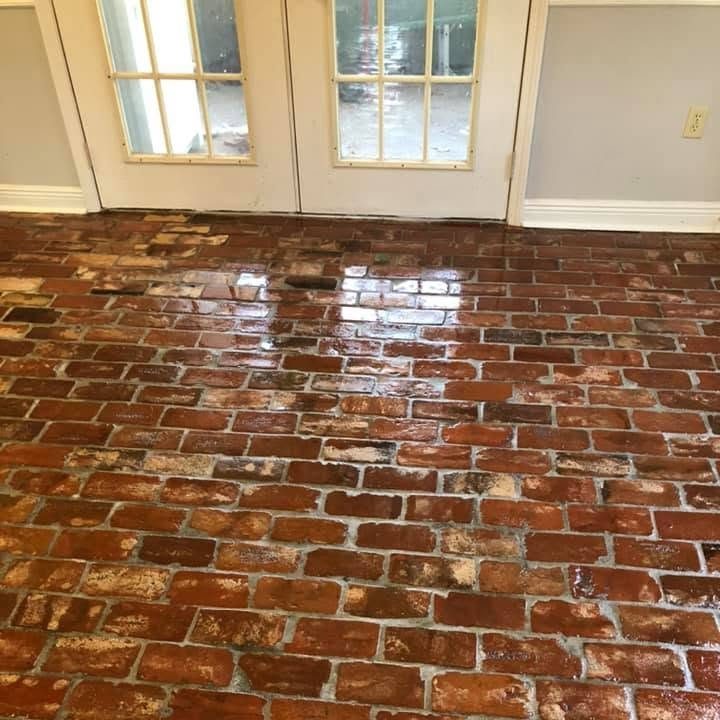 Sealed red brick floor in running bond before white French doors