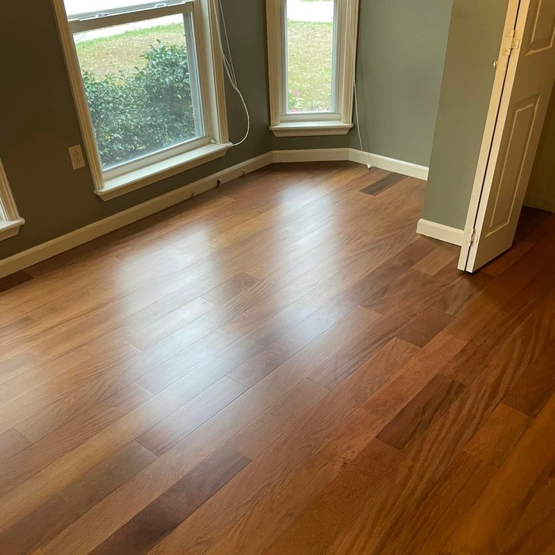 Bedroom with a new wide-plank reddish-brown hardwood floor