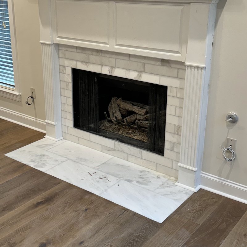 Fireplace mantel with fluted legs around marble subway tile
