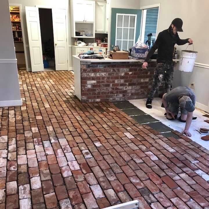 Reclaimed red brick kitchen floor being laid in a running pattern