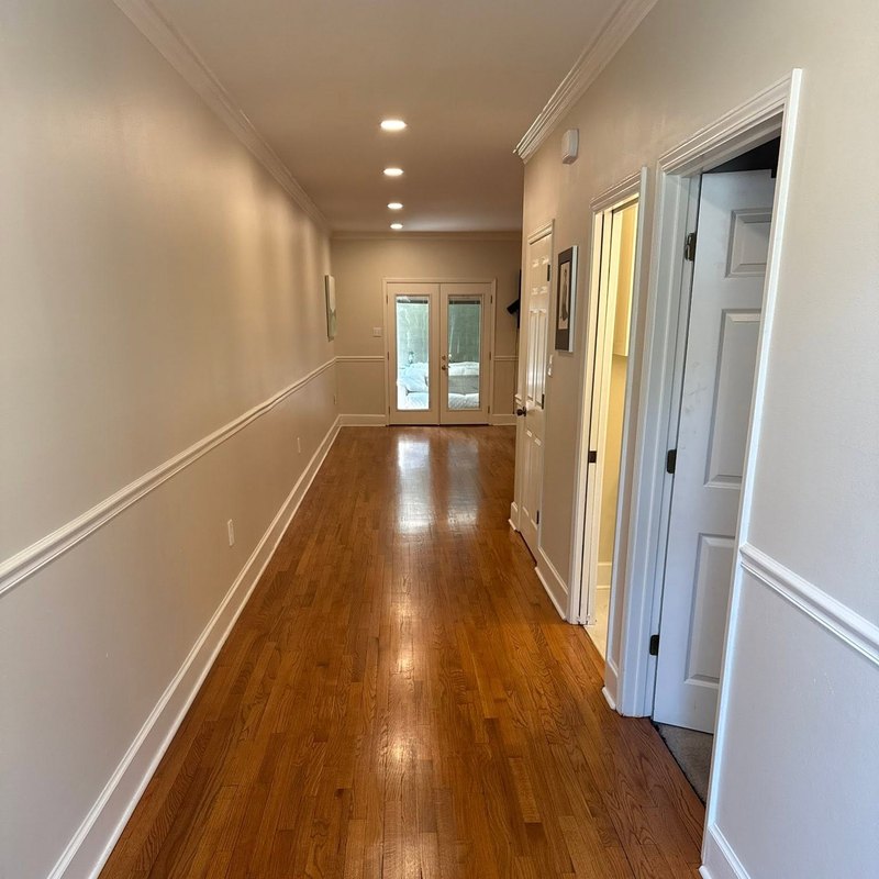 Honey oak hall floor with white chair rail and baseboards