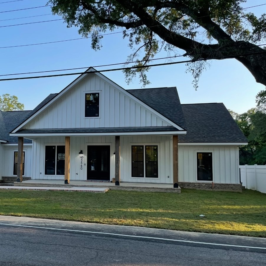 White home with a porch on natural wood posts