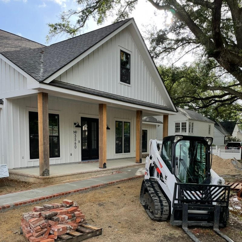 Nearly done farmhouse with a brick-edged walk and wood posts